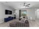 Cozy living room featuring a sectional sofa, a ceiling fan, and a sliding glass door to the backyard at 8737 E Nichols Ave, Mesa, AZ 85209