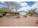 Gravel backyard with mature trees and a covered patio at 8741 W Osborn Rd, Phoenix, AZ 85037