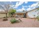 Backyard featuring gravel, covered patio, and mature landscaping at 8741 W Osborn Rd, Phoenix, AZ 85037