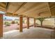 Large covered patio with brick pillars and ceiling fan overlooks landscaped backyard at 8741 W Osborn Rd, Phoenix, AZ 85037