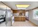 Kitchen featuring stainless steel refrigerator, white oven, microwave, tile floors, and wood cabinets at 8741 W Osborn Rd, Phoenix, AZ 85037