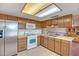 Kitchen featuring a full suite of appliances, tile flooring, and wood cabinets at 8741 W Osborn Rd, Phoenix, AZ 85037