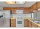 Kitchen with stainless steel refrigerator, white oven, microwave, tile backsplash, and wood cabinets at 8741 W Osborn Rd, Phoenix, AZ 85037