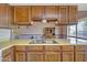 Traditional kitchen with wood cabinets, neutral countertops, and a double basin stainless steel sink at 8741 W Osborn Rd, Phoenix, AZ 85037