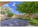 Backyard showcasing a lush lawn, mature trees, brick patio, and privacy wall at 9413 W Williams St, Tolleson, AZ 85353