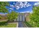 Backyard view features a storage shed on a sunny day, surrounded by lush landscaping at 9413 W Williams St, Tolleson, AZ 85353