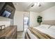 Bedroom with a large bed, wooden dresser, TV, and a doorway leading to the bathroom at 9413 W Williams St, Tolleson, AZ 85353