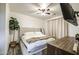Neutral bedroom with a cozy upholstered bed, a mounted TV, and a potted plant at 9413 W Williams St, Tolleson, AZ 85353