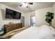 Bright bedroom featuring a wooden dresser, a TV, and a door to the bathroom at 9413 W Williams St, Tolleson, AZ 85353