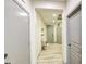 Hallway with light wood-look floors, neutral walls, and multiple doors, creating a clean and inviting space at 9413 W Williams St, Tolleson, AZ 85353