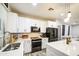 Modern kitchen features white cabinetry, stainless steel appliances, and an island with quartz countertops at 9413 W Williams St, Tolleson, AZ 85353
