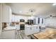 Bright, modern kitchen with white cabinets, stainless steel appliances, and an island with bar stools at 9413 W Williams St, Tolleson, AZ 85353
