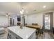 Open floor plan with a kitchen island and a wooden table leading to the living room at 9413 W Williams St, Tolleson, AZ 85353