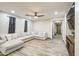 Large, inviting living room with a plush gray sectional, stylish wood-look floors, and neutral décor at 9413 W Williams St, Tolleson, AZ 85353