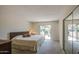 Bright bedroom with carpeted floors, closet, and slider to fenced backyard patio at 964 Leisure World --, Mesa, AZ 85206