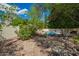 A backyard boasts a serene pool, a charming firepit, and verdant trees and shrubs at 1002 E Topeka Dr, Phoenix, AZ 85024