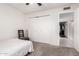 This bedroom features white walls, gray carpet, and a closet with folding doors at 1002 E Topeka Dr, Phoenix, AZ 85024