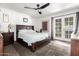 Main bedroom featuring dark hardwood floors, ceiling fan, and a set of patio doors at 1002 E Topeka Dr, Phoenix, AZ 85024
