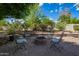 An outdoor fire pit is surrounded by four chairs set on a brick patio at 1002 E Topeka Dr, Phoenix, AZ 85024