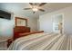 Bright bedroom with ceiling fan, tv, wood dresser and view to ensuite bathroom at 10177 E La Palma Ave, Gold Canyon, AZ 85118