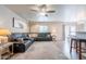 Open living room featuring a large leather sofa, ceiling fan, hardwood floors, and an adjacent dining area at 10177 E La Palma Ave, Gold Canyon, AZ 85118
