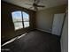 Cozy bedroom featuring a ceiling fan, carpet flooring, and a large window for natural light at 10736 W Swayback Pass, Peoria, AZ 85383