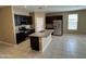 Modern kitchen featuring an island, stainless steel appliances, granite countertops, and dark cabinets at 10736 W Swayback Pass, Peoria, AZ 85383