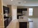 Modern kitchen featuring an island, stainless steel appliances, granite countertops, and dark cabinets at 10736 W Swayback Pass, Peoria, AZ 85383