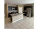 Modern kitchen featuring an island, stainless steel appliances, granite countertops, and dark cabinets at 10736 W Swayback Pass, Peoria, AZ 85383