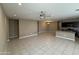 Spacious living room with neutral tile flooring, ceiling fan, chandelier, and open access to the kitchen at 10736 W Swayback Pass, Peoria, AZ 85383