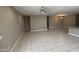 Neutral-toned living room featuring tile flooring and access to kitchen and dining area, ideal for entertaining at 10736 W Swayback Pass, Peoria, AZ 85383