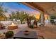 Backyard oasis with a firepit, seating, grill, palm trees, and an orange sunset sky at 10907 E Bella Vista Dr, Scottsdale, AZ 85259