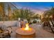 Entertainer's backyard with a fire pit, seating area, grill, and lush desert landscaping at 10907 E Bella Vista Dr, Scottsdale, AZ 85259