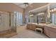 Large bathroom with tub, shower, dual vanities, a large mirror, and bright shuttered windows at 10907 E Bella Vista Dr, Scottsdale, AZ 85259