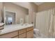Well-lit bathroom featuring a spacious vanity, large mirror, and a combined shower and tub at 10907 E Bella Vista Dr, Scottsdale, AZ 85259