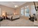 Serene bedroom with a ceiling fan, large windows, and a cozy sitting area at 10907 E Bella Vista Dr, Scottsdale, AZ 85259