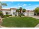 Charming single-story home with a manicured lawn, mature palm trees, and a three-car garage at 10907 E Bella Vista Dr, Scottsdale, AZ 85259