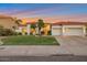 Well-maintained home boasts manicured front lawn, mature trees, and three-car garage at sunset at 10907 E Bella Vista Dr, Scottsdale, AZ 85259