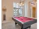 Game room with a pool table, chandelier, and plantation shutters with natural light at 10907 E Bella Vista Dr, Scottsdale, AZ 85259