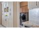 Convenient, bright laundry room with custom cabinets and stainless steel washer and dryer at 10907 E Bella Vista Dr, Scottsdale, AZ 85259