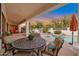 Covered patio with stylish dining table and chairs overlooking the backyard pool area at 10907 E Bella Vista Dr, Scottsdale, AZ 85259