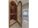 Unique wine cellar featuring wooden racks and glass door, adjacent to a living space at 10907 E Bella Vista Dr, Scottsdale, AZ 85259