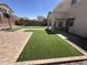 Spacious backyard featuring artificial turf, brick patio, covered patio, and a basketball hoop at 11460 W Eden Mckenzie Dr, Surprise, AZ 85378
