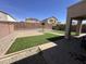 Well-maintained backyard with artificial turf, paved patio, and block fence at 11460 W Eden Mckenzie Dr, Surprise, AZ 85378