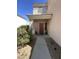 View of the entry door featuring a covered porch, desert landscaping, and neutral tones at 11460 W Eden Mckenzie Dr, Surprise, AZ 85378