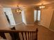 Spacious foyer with tile flooring and wooden staircase featuring decorative lighting fixtures at 11460 W Eden Mckenzie Dr, Surprise, AZ 85378