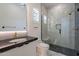 Modern bathroom with glass shower, black marble countertop, sleek cabinets, and pendant lighting at 14141 E Highland Ave, Fountain Hills, AZ 85268