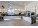 Spacious kitchen features black marble countertops, modern lighting, stainless steel appliances, and wood floors at 14141 E Highland Ave, Fountain Hills, AZ 85268