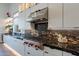 Modern kitchen showcases black marble countertops, sleek stainless steel appliances, white cabinetry, and wood flooring at 14141 E Highland Ave, Fountain Hills, AZ 85268