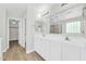 Well-lit bathroom featuring dual sinks, white cabinetry, large mirrors, and a separate shower at 14200 W Larkspur Dr, Surprise, AZ 85379